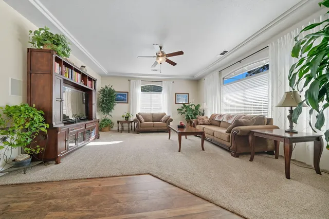 a living room with furniture a large window and a flat screen tv
