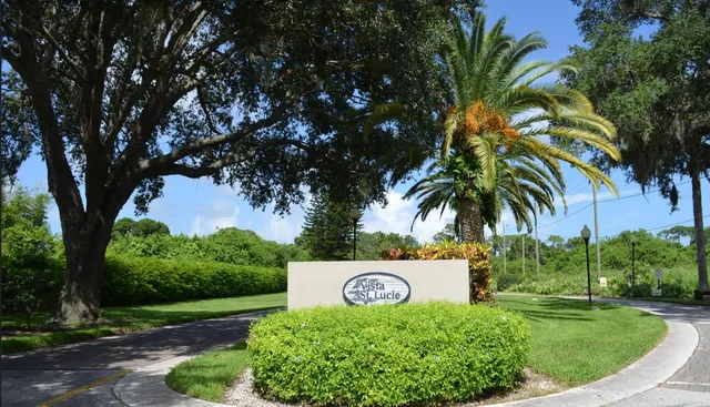 a sign that is sitting in front of a tree