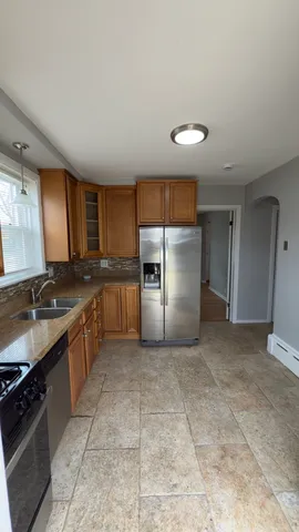 a kitchen with stainless steel appliances granite countertop a stove a sink and a refrigerator