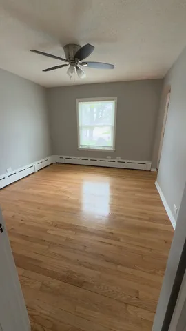 a view of a room with wooden floor and a window