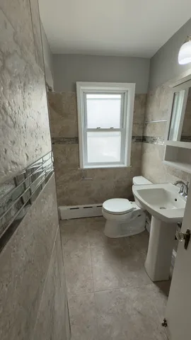 a bathroom with a sink toilet and window