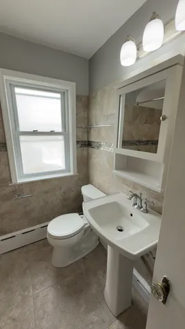 a bathroom with a sink mirror and toilet