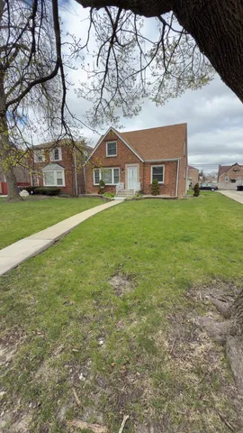 a front view of a house with a garden and trees