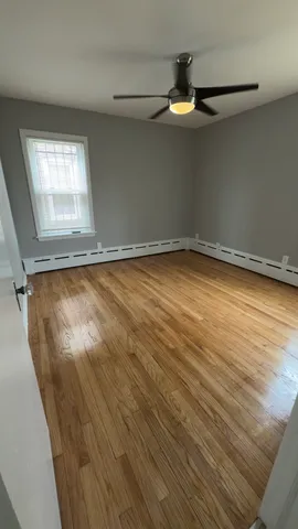 a view of a room with wooden floor and fan