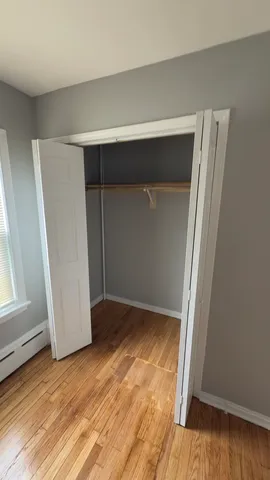 an empty room with wooden floor and closet