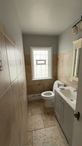 a bathroom with a toilet sink and mirror