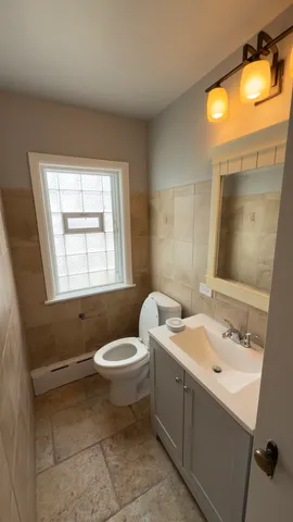 a bathroom with a toilet sink and mirror