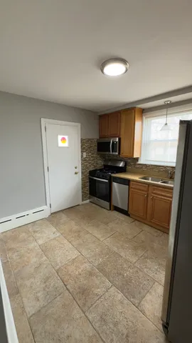 a kitchen with stainless steel appliances granite countertop a stove a sink and a refrigerator