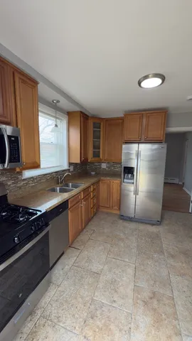 a kitchen with granite countertop a refrigerator stove top oven and sink