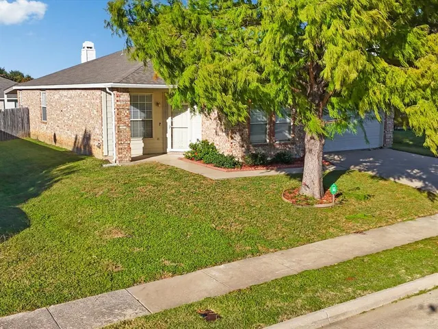a front view of a house with yard and trees