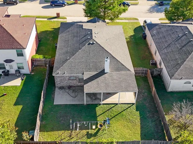 an aerial view of a house with garden space and a patio