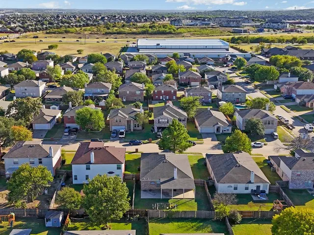 an aerial view of residential houses with outdoor space and swimming pool