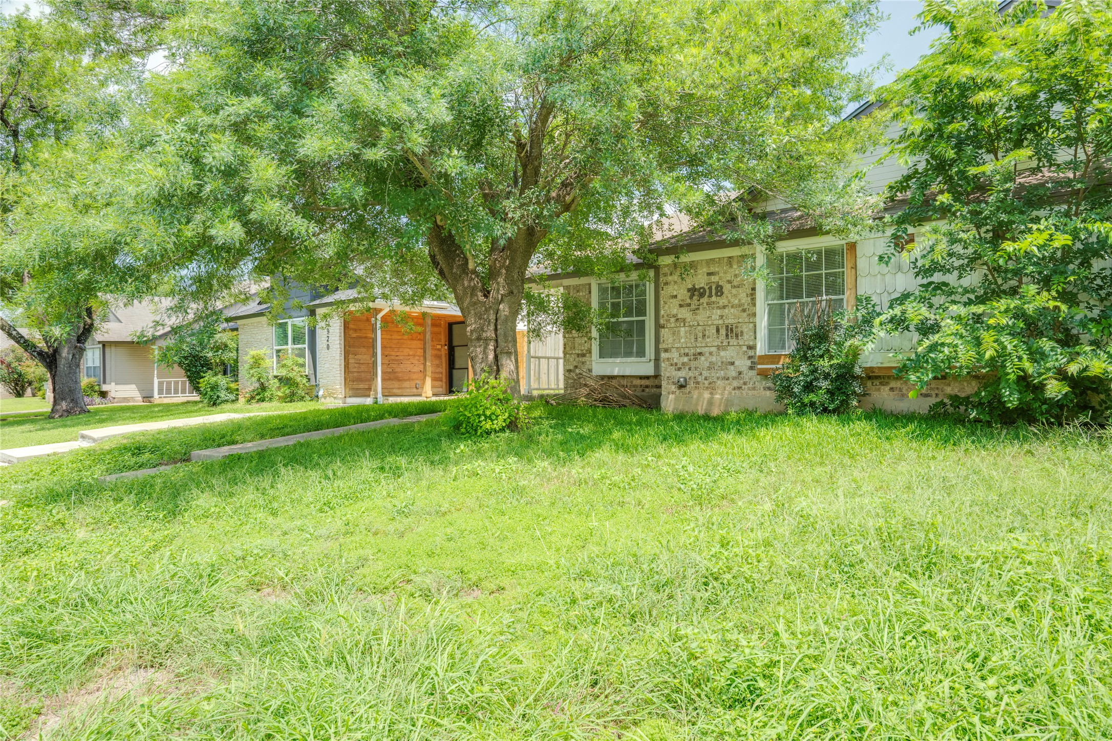 7918 West Gate Boulevard Austin, TX 78745 - Photo 27 of 31 Mature trees provide ample shade to this inviting brick and siding residence.