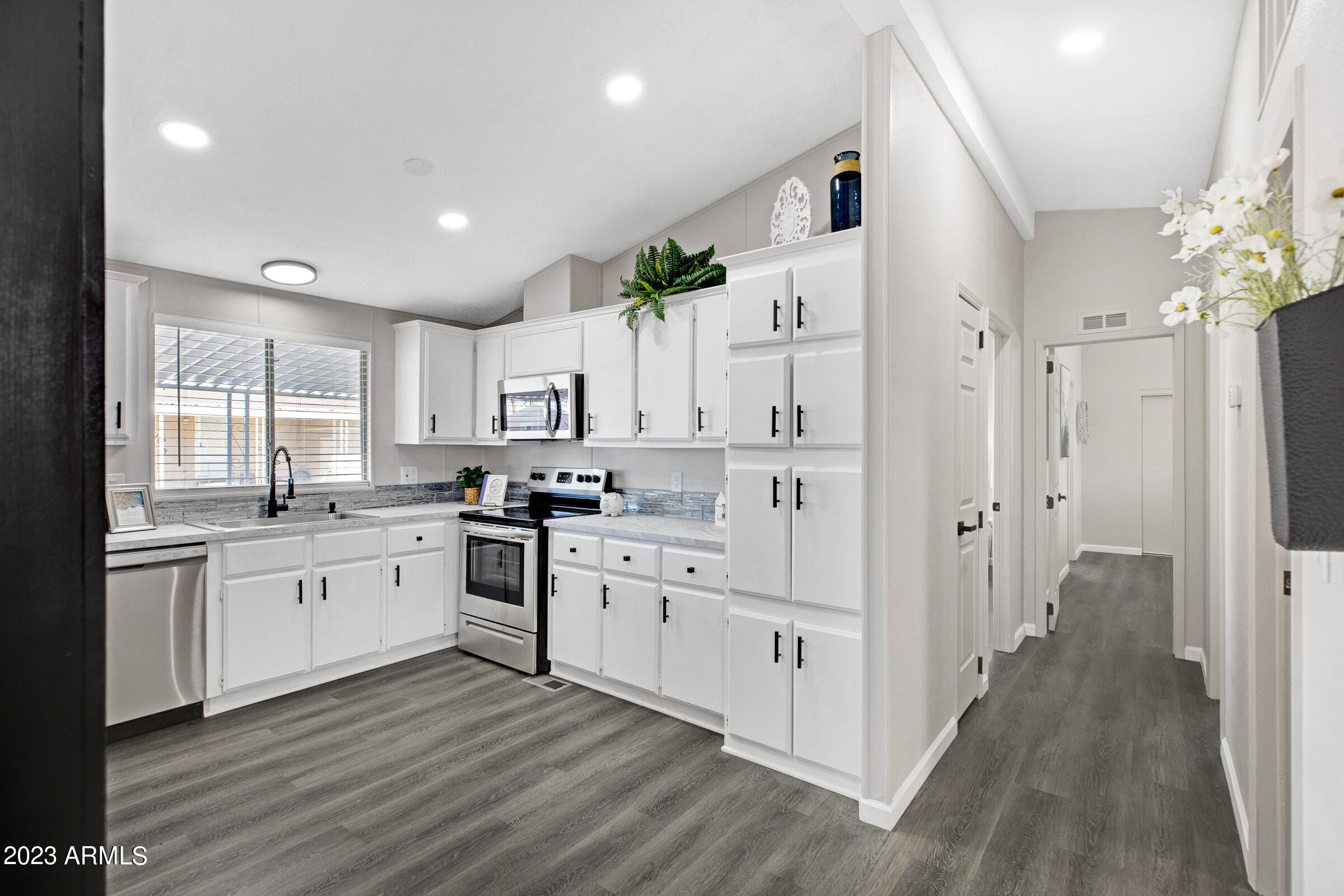 301 South Signal Butte Road, Unit 815 Apache Junction, AZ 85120 - Photo 11 of 15 a large kitchen with stainless steel appliances lots of white cabinets