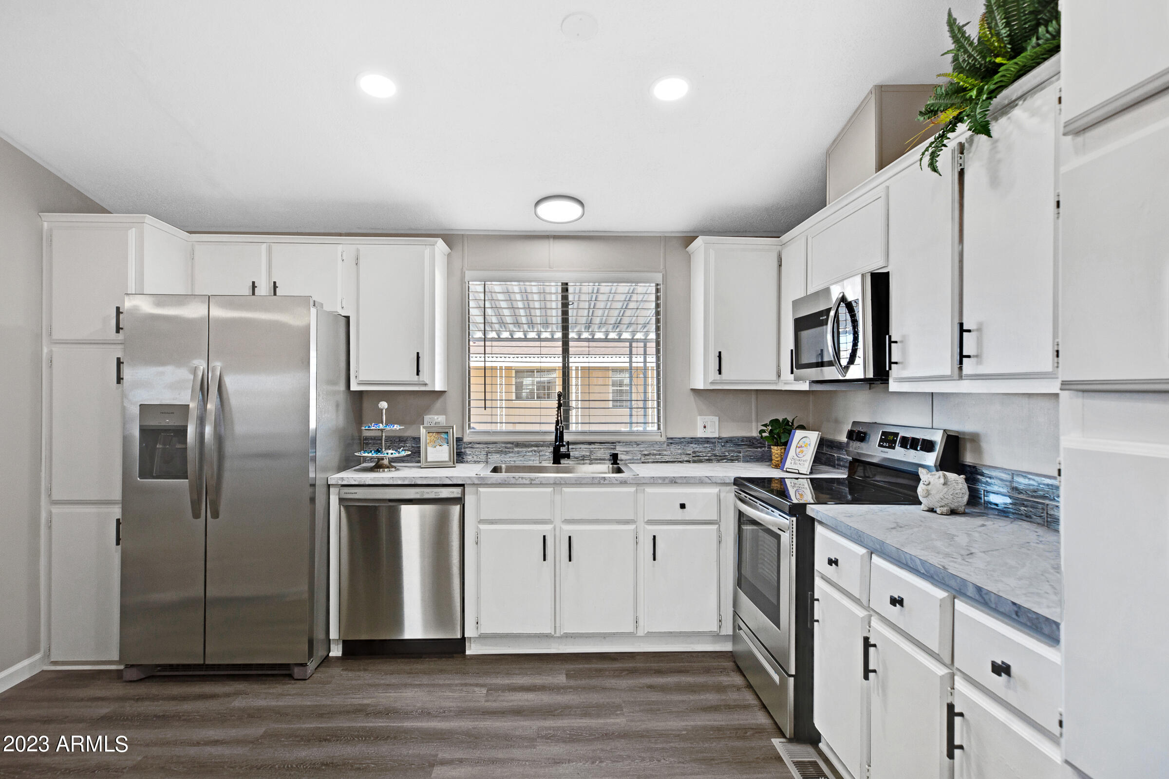 301 South Signal Butte Road, Unit 815 Apache Junction, AZ 85120 - Photo 10 of 15 a kitchen with stainless steel appliances granite countertop a sink a stove a refrigerator and cabinets