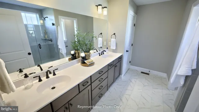 a spacious bathroom with a double vanity sink a mirror and a shower