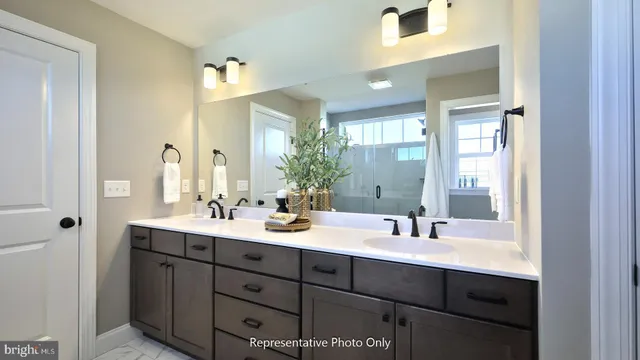 a bathroom with double vanity sinks and a mirror