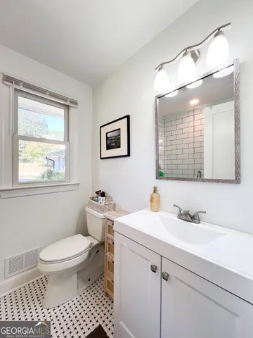 a bathroom with a sink a toilet and mirror