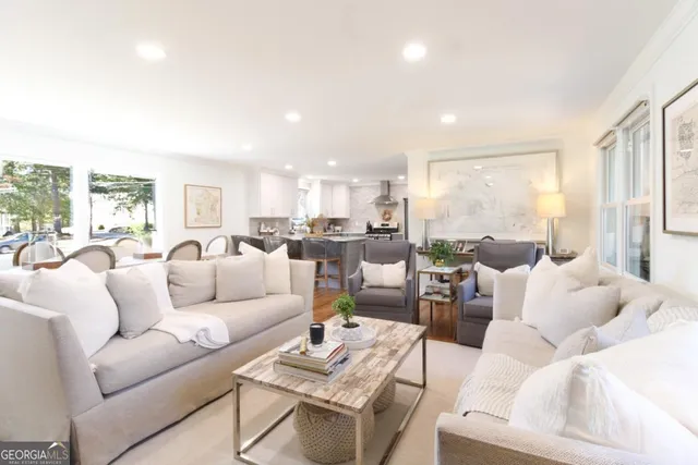 a living room with furniture wooden floor and a large window
