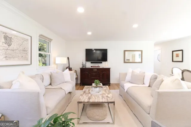a living room with furniture a flat screen tv and a fireplace