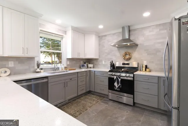 a kitchen with stainless steel appliances granite countertop a sink a stove and a refrigerator