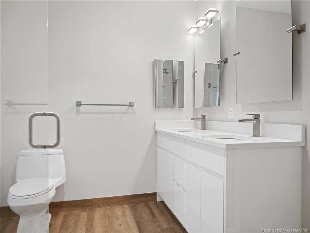 41 Southwest Seminole Street, Unit 208 Stuart, FL 34994 - Photo 29 of 46 a bathroom with a sink a toilet and a mirror