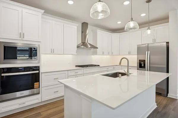 a kitchen with stainless steel appliances a stove a sink a refrigerator and cabinets