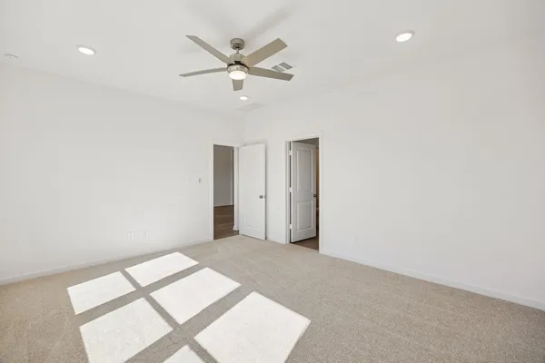 an empty room with a window and a fan