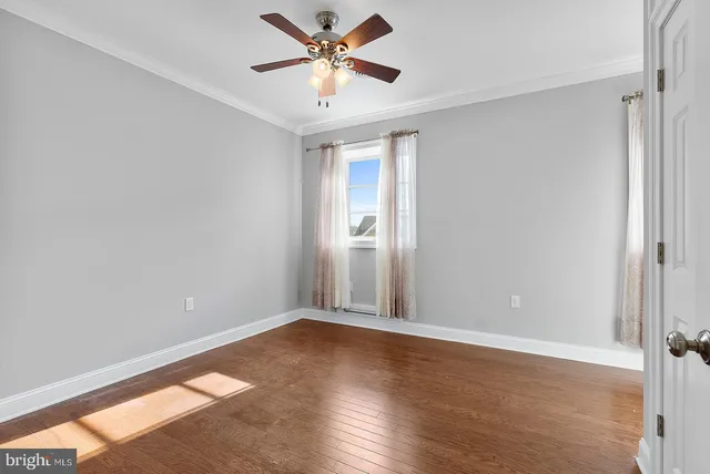 a view of a big room with wooden floor and a chandelier fan