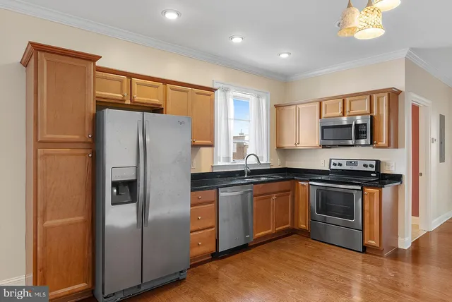 a kitchen with stainless steel appliances granite countertop a refrigerator stove top oven and sink