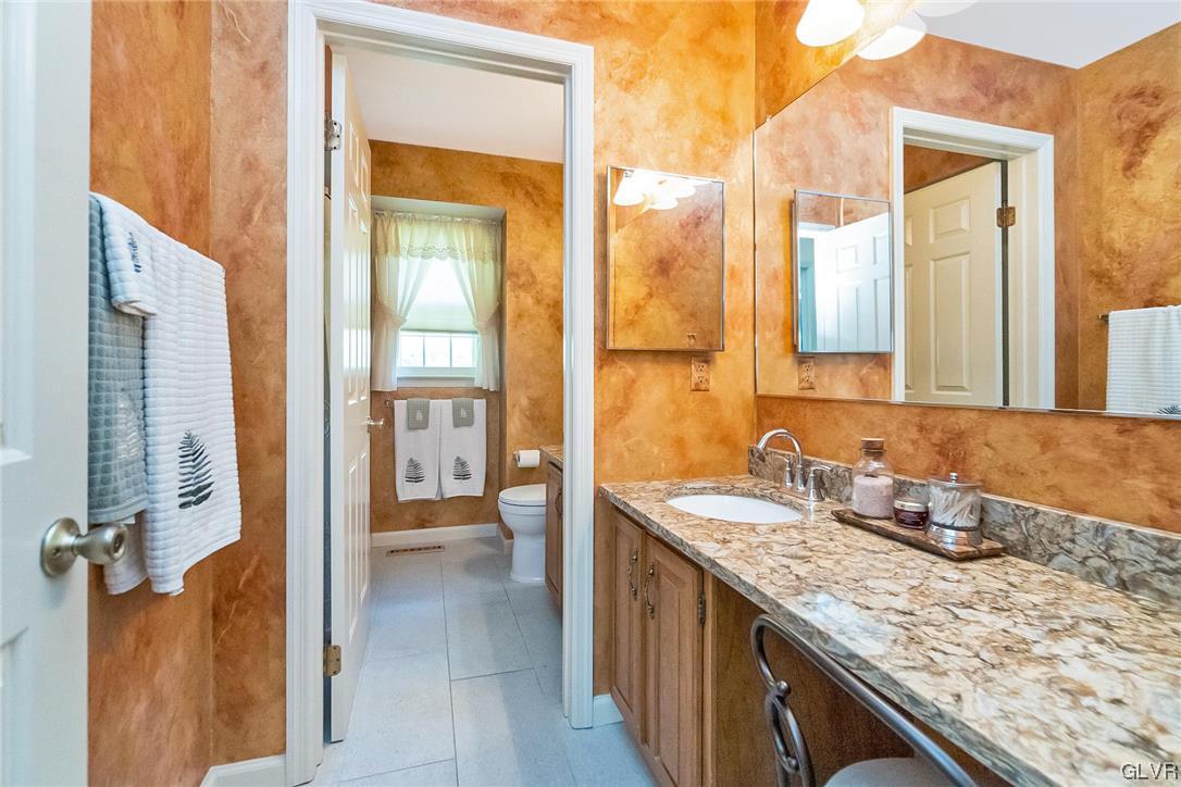 2285 Woodbarn Road Lower Macungie Township, PA 18062 - Photo 33 of 45 a bathroom with a granite countertop sink and a mirror