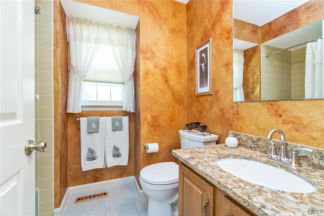 2285 Woodbarn Road Lower Macungie Township, PA 18062 - Photo 34 of 45 a bathroom with a granite countertop toilet sink and mirror