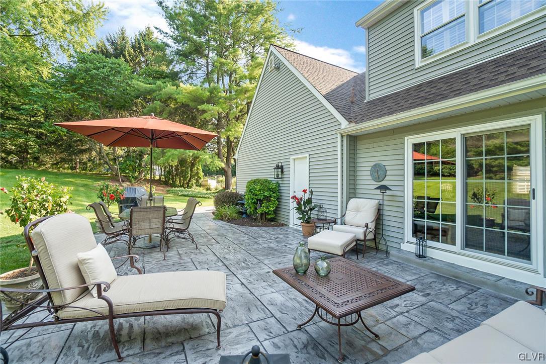 2285 Woodbarn Road Lower Macungie Township, PA 18062 - Photo 42 of 45 a view of a patio with chairs and table under an umbrella with a barbeque