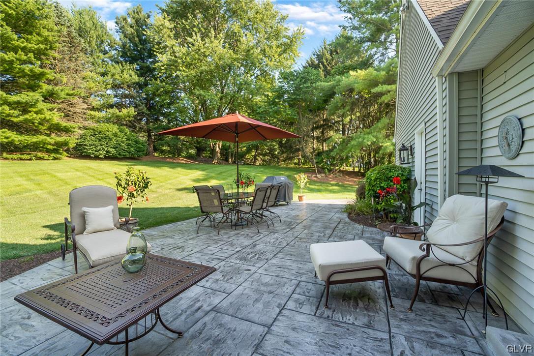 2285 Woodbarn Road Lower Macungie Township, PA 18062 - Photo 44 of 45 a view of a patio with table and chairs under an umbrella
