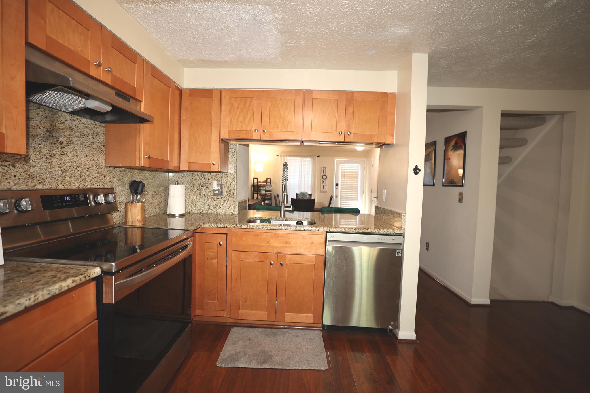 1939 Belmont Ridge Court Reston, VA 20191 - Photo 4 of 14 a kitchen with stainless steel appliances granite countertop a refrigerator a sink dishwasher a stove and white countertops with wooden floor