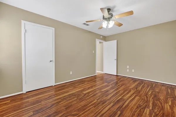 a view of an empty room with wooden floor