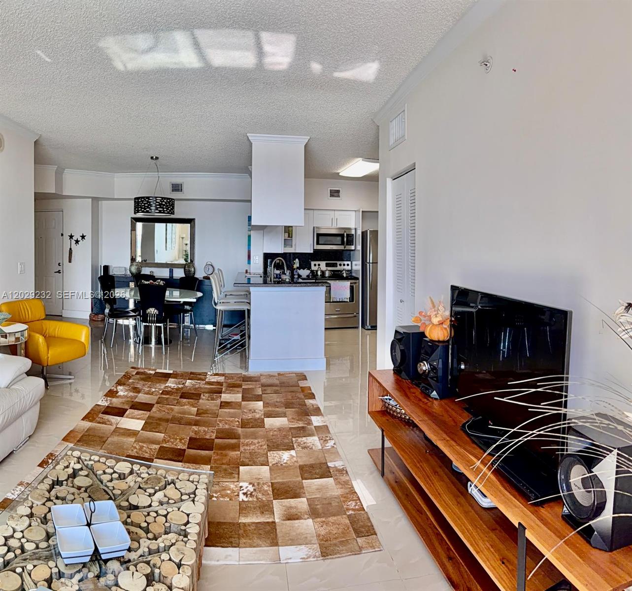 17100 North Bay Road, Unit 1605 Sunny Isles Beach, FL 33160 - Photo 10 of 52 a living room with furniture and a flat screen tv