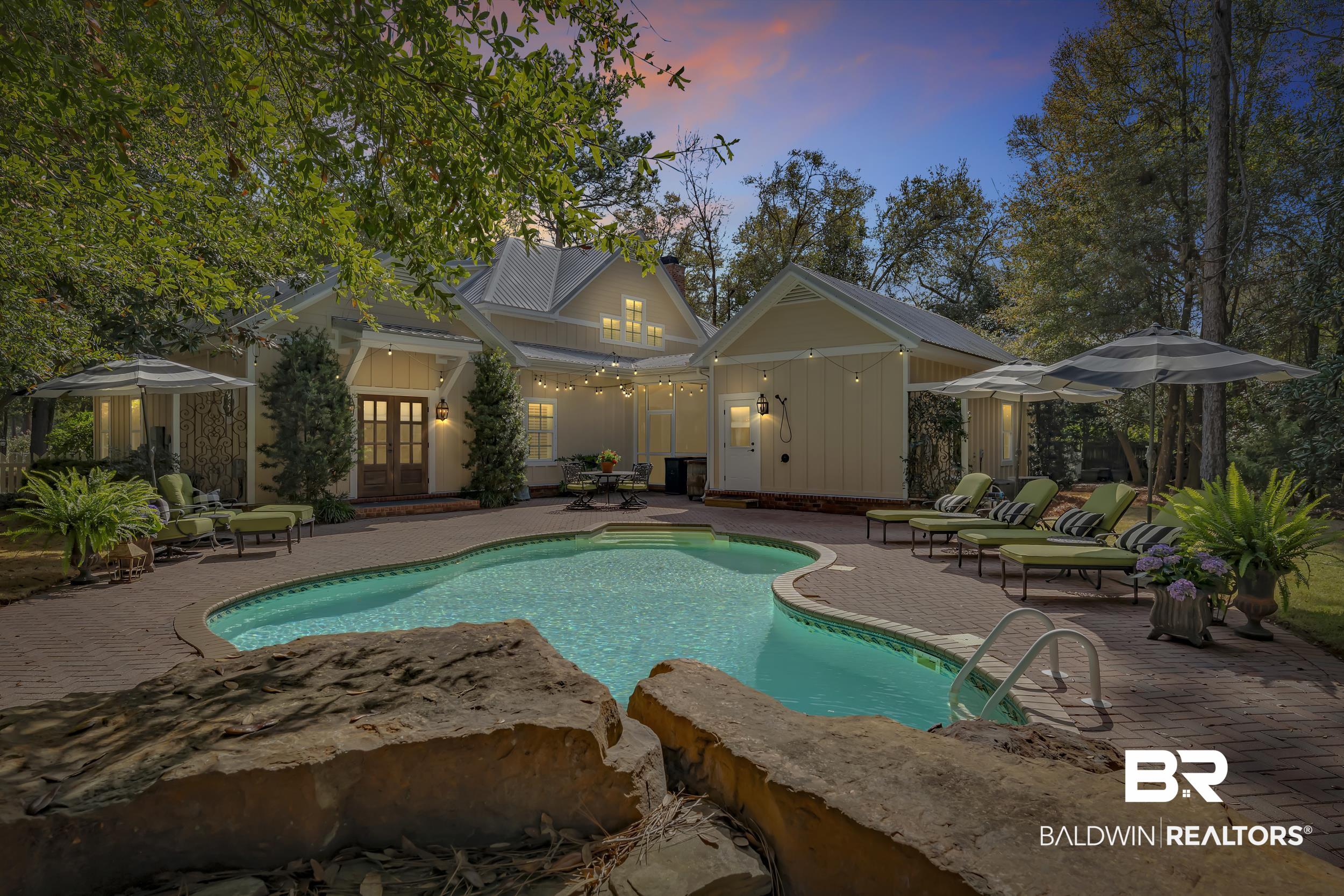 12161 Jessamine Street Magnolia Springs, AL 36555 - Photo 53 of 70 Pool at dusk featuring an outdoor pool, a patio, french doors, and an outbuilding