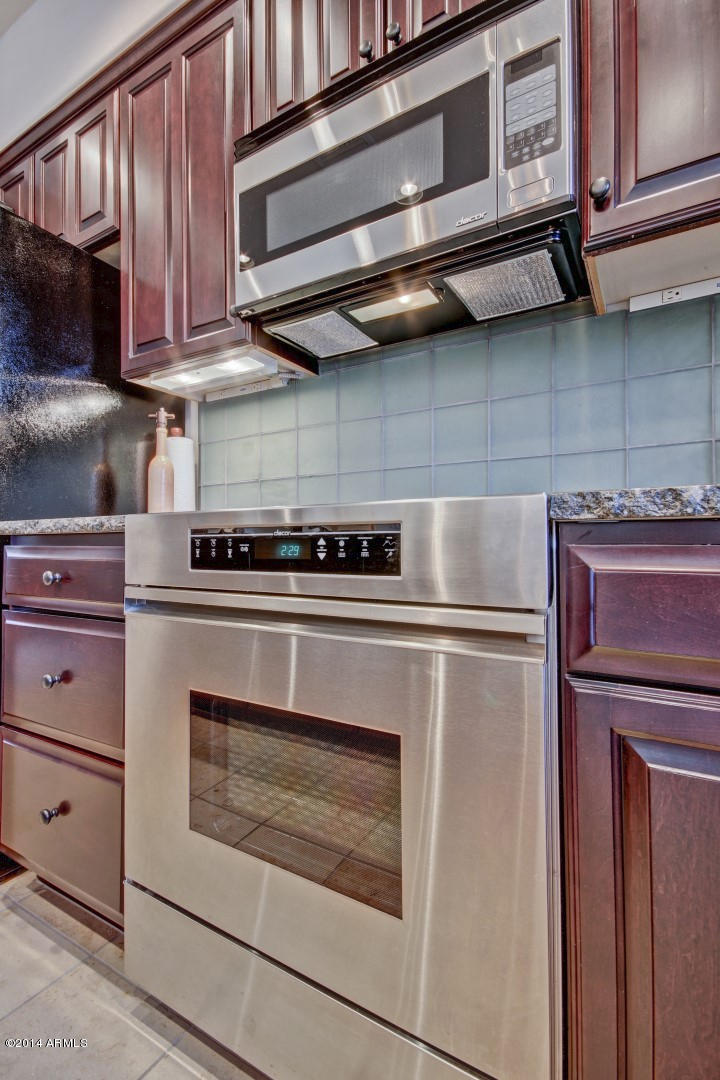 3935 East Rough Rider Road, Unit 1089 Phoenix, AZ 85050 - Photo 17 of 71 a kitchen with stainless steel appliances granite countertop a stove and a microwave