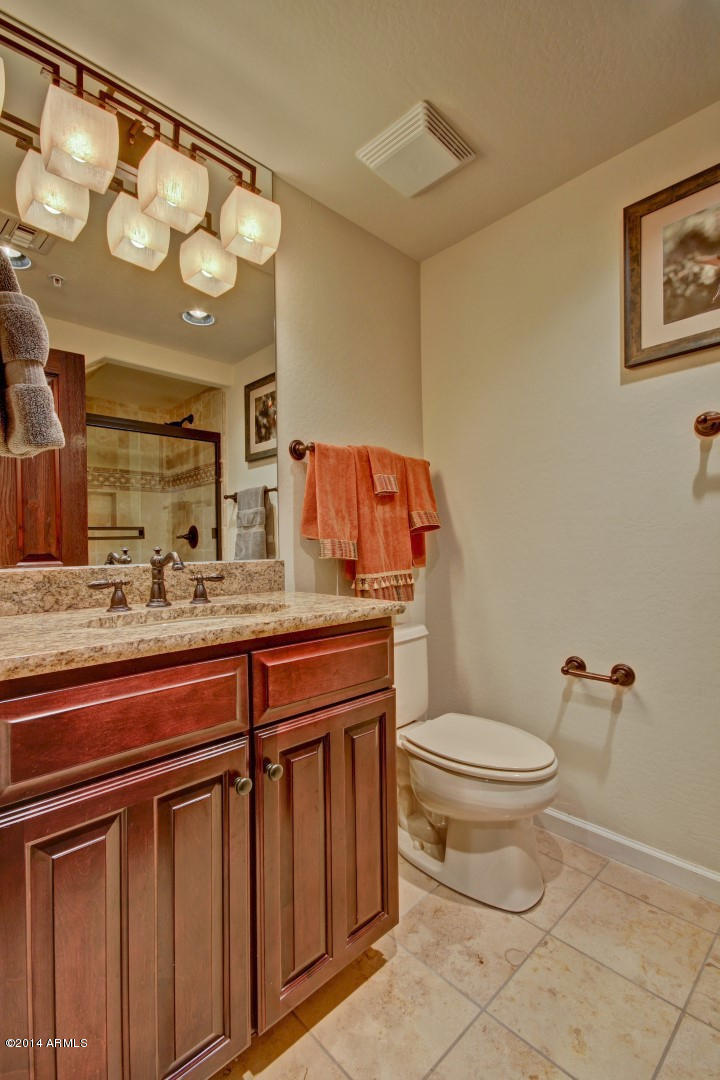 3935 East Rough Rider Road, Unit 1089 Phoenix, AZ 85050 - Photo 31 of 71 a bathroom with a toilet a sink and mirror