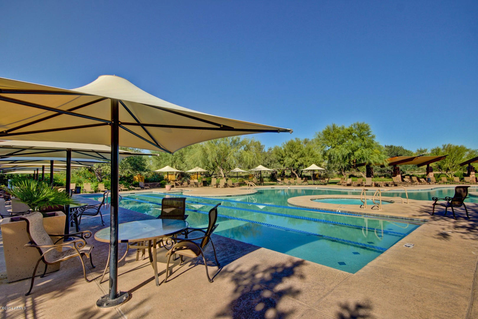3935 East Rough Rider Road, Unit 1089 Phoenix, AZ 85050 - Photo 61 of 71 a view of a swimming pool with a table and chairs under an umbrella