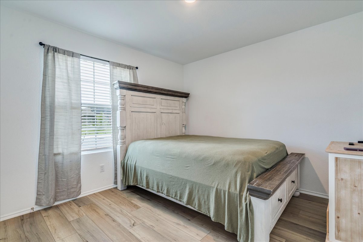 389 Salt Springs Road Kyle, TX 78640 - Photo 17 of 30 A quiet retreat featuring warm hardwood flooring and ample natural light from the well-placed window.