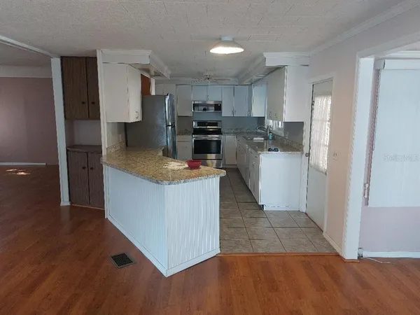 a kitchen with refrigerator and cabinets