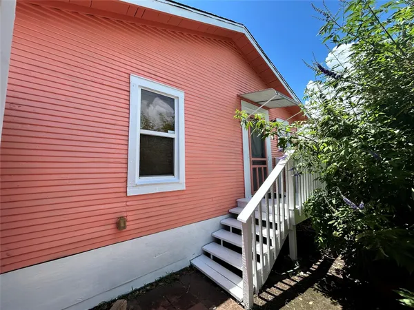 a view of a house with a small yard and wooden floor and fence