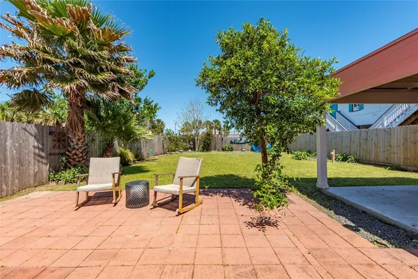 a view of a patio with a table and chairs under an umbrella