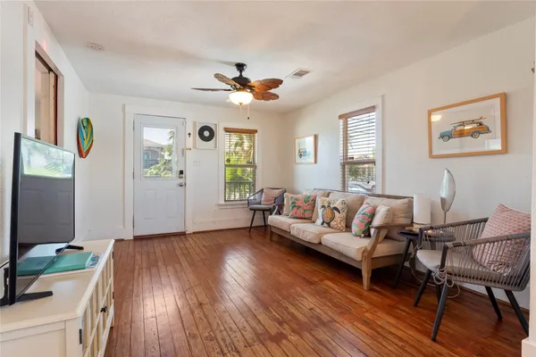 a living room with furniture and a wooden floor