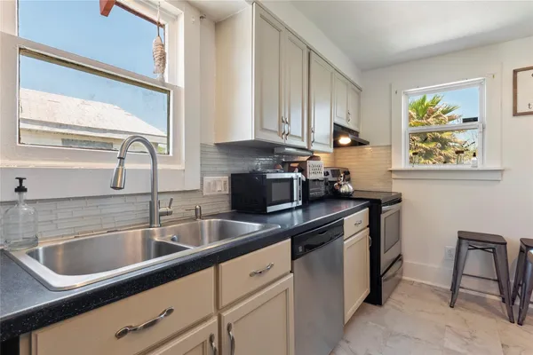 a kitchen with stainless steel appliances granite countertop a sink stove and cabinets
