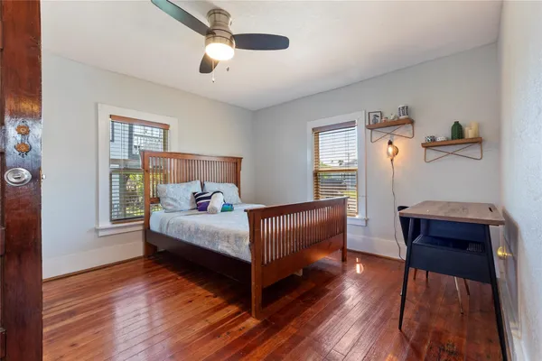 a bedroom with a bed and wooden floor