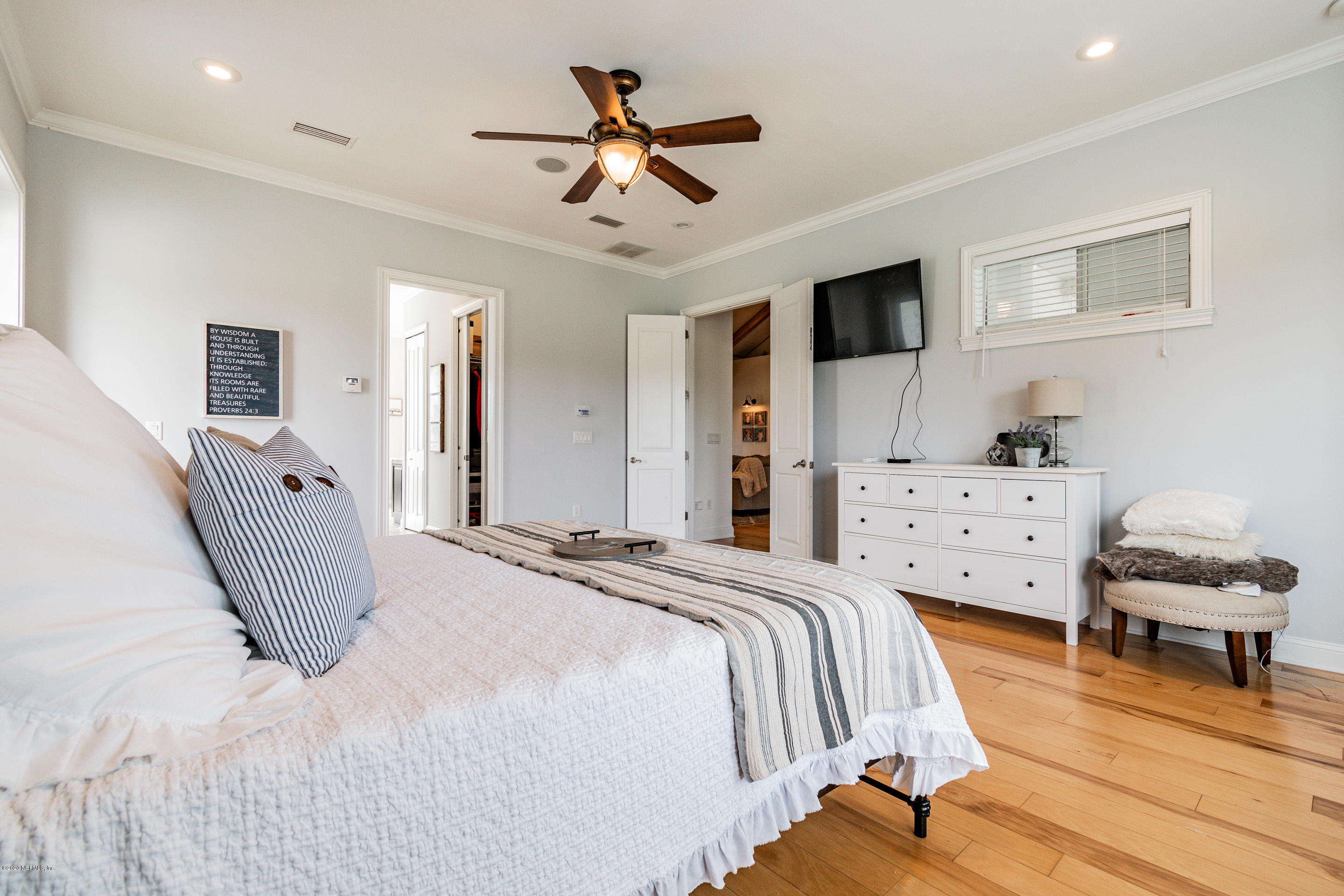 14689 Diamond Ranch Drive Jacksonville, FL 32234 - Photo 30 of 76 a bedroom with a bed and a chandelier