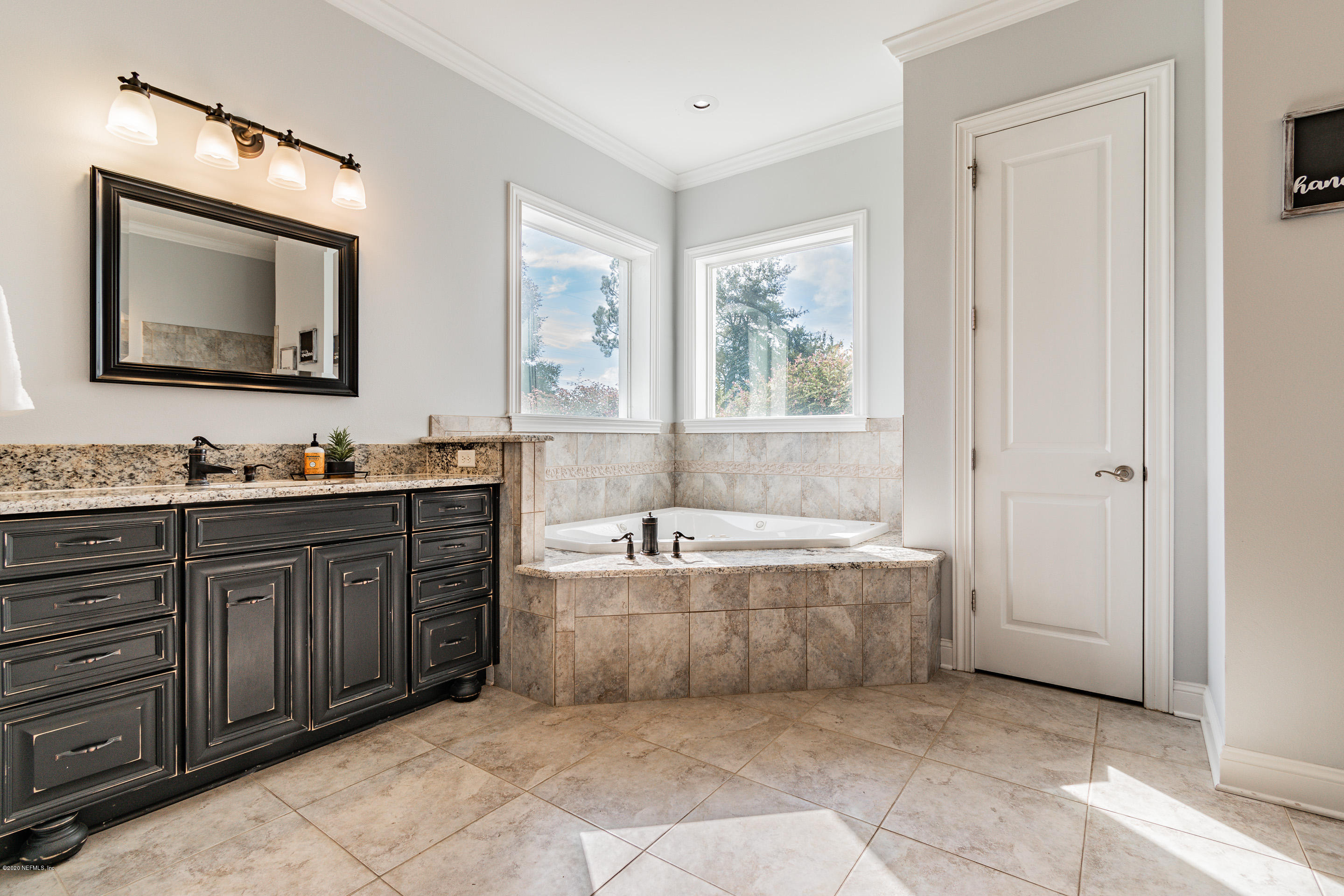 14689 Diamond Ranch Drive Jacksonville, FL 32234 - Photo 34 of 76 a spacious bathroom with a tub sink and mirror